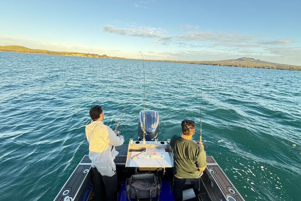 boys fishing from back of boat