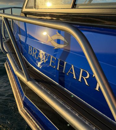 Bravehart logo on boat during sunset